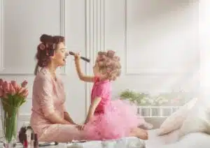Mother in athleisure wear and daughter do makeup and hair
