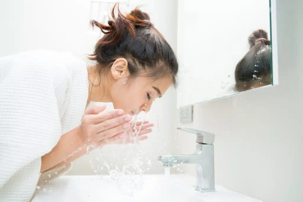 Young Asian woman washing face with a cleansing balm