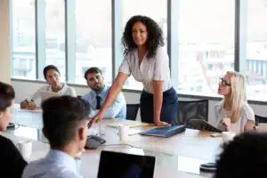 A female leader shares social-emotional learning techniques with others a conference table