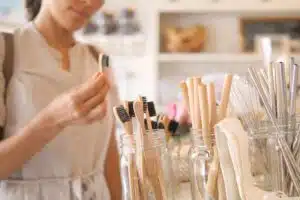A young woman chooses a eco-friendly bamboo toothbrush to reduce waste