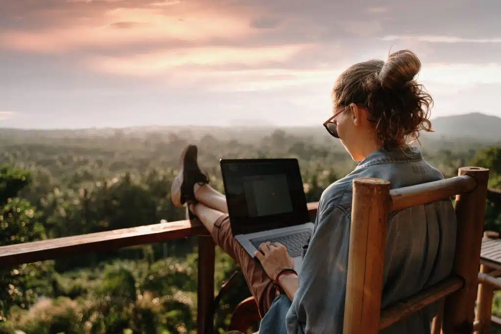 Young business woman working on a laptop while overlooking a scenic view