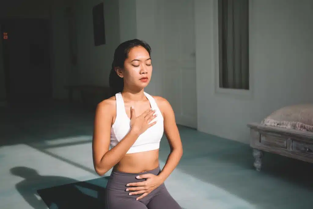 An Asian woman engages in a breathwork practice