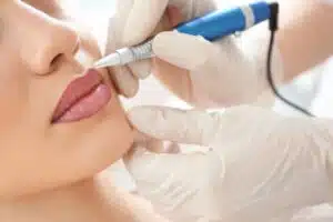 A woman gets permanent makeup applied to the lips