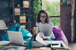 An attractive woman working remotely with coffee inhand