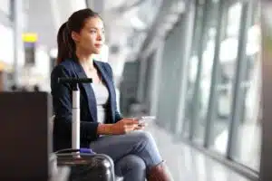 A female traveler on her cell phone waiting for a flight at the airport