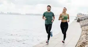 Joyful couple jogging along the coast, demonstrating a healthy lifestyle.