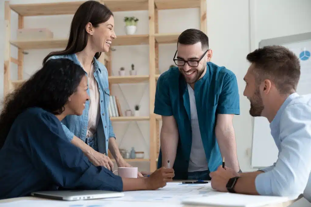 Four diverse colleagues gathered around a table collaborating.