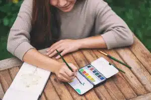 A woman painting with water colors