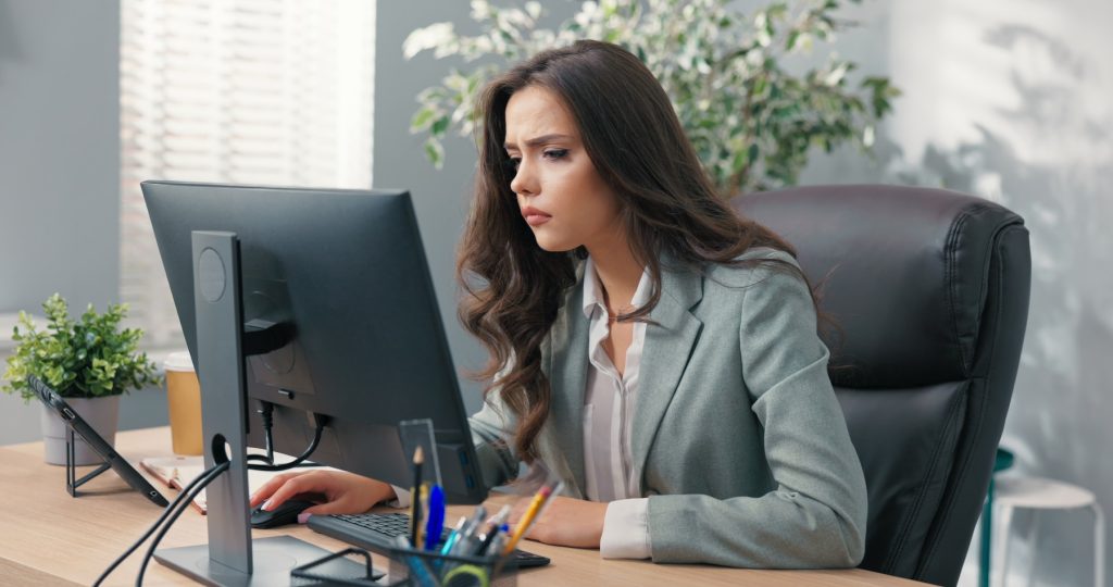 A woman at a desk looking at her computer